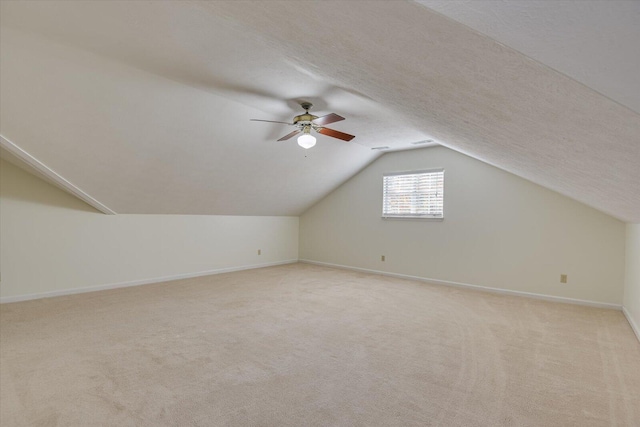 bonus room featuring light carpet, a textured ceiling, ceiling fan, and lofted ceiling