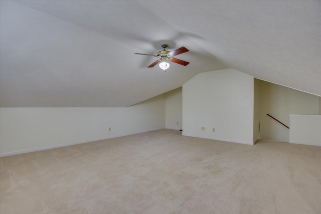 bonus room with light carpet, a textured ceiling, vaulted ceiling, and ceiling fan