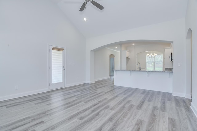 326 Agape Ln, Trenton, SC 29847 - unfurnished living room featuring high vaulted ceiling, ceiling fan, arched walkways, a chandelier, and light wood-style flooring