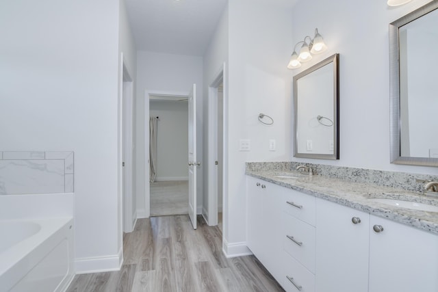326 Agape Ln, Trenton, SC 29847 - full bathroom featuring double vanity, a garden tub, and wood finished floors