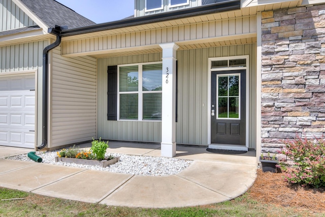 326 Agape Ln, Trenton, SC 29847 - entrance to property featuring a garage, stone siding, roof with shingles, and covered porch