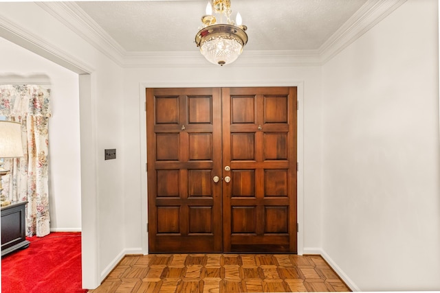 foyer featuring ornamental molding, a textured ceiling, parquet flooring, and an inviting chandelier