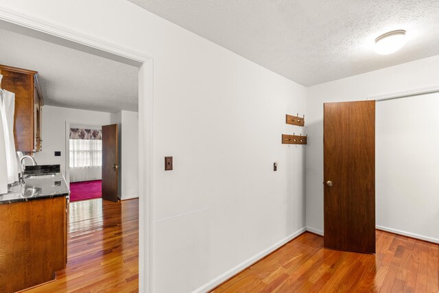 spare room with sink, wood-type flooring, and a textured ceiling