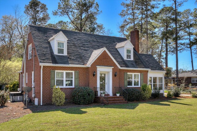 413 Park Dr, Waynesboro, GA 30830 - cape cod house with brick siding, a chimney, a front lawn, and a shingled roof