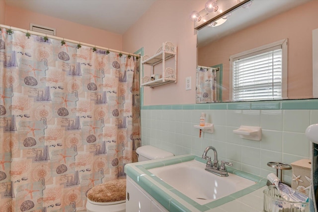 413 Park Dr, Waynesboro, GA 30830 - full bathroom with curtained shower, tile walls, a wainscoted wall, toilet, and vanity