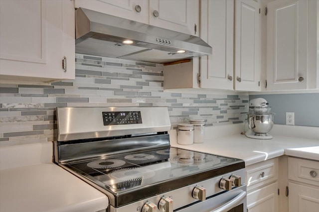 413 Park Dr, Waynesboro, GA 30830 - kitchen with under cabinet range hood, white cabinetry, stainless steel range with electric cooktop, light countertops, and decorative backsplash