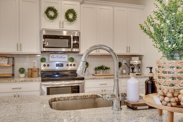 1207 Mary Hill Ct, Evans, GA 30809 - kitchen with decorative backsplash, white cabinetry, light stone counters, a sink, and stainless steel appliances