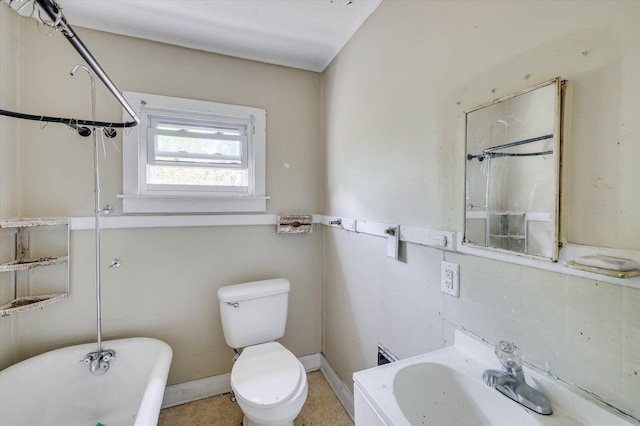 bathroom featuring toilet, sink, and a tub