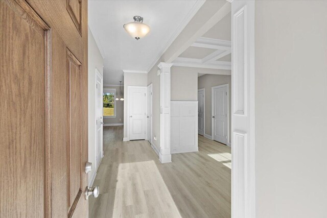 corridor featuring baseboards, light wood-style floors, decorative columns, and crown molding