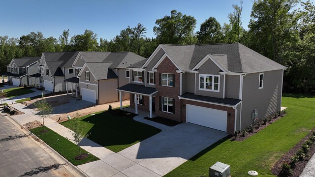 view of front of property featuring a garage, concrete driveway, brick siding, and a front yard