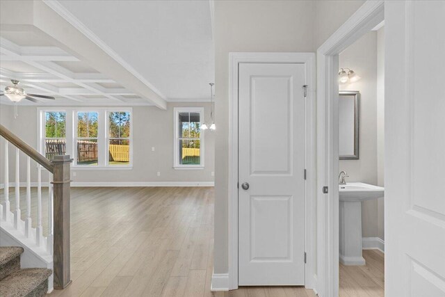 interior space featuring light wood-style flooring, stairs, coffered ceiling, and a wealth of natural light