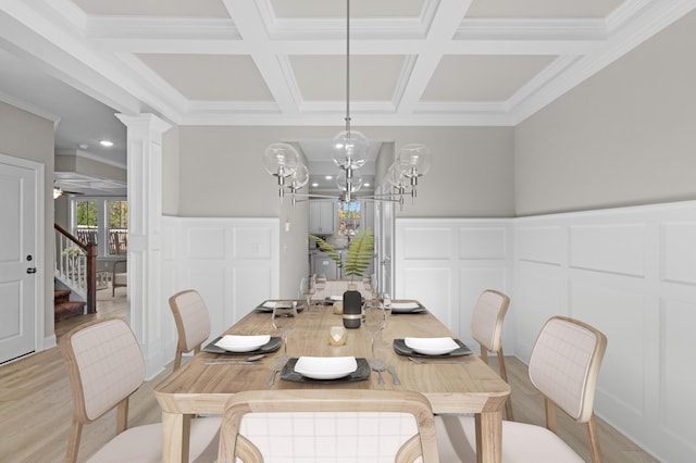 dining area featuring ornate columns, light wood-style flooring, coffered ceiling, and a decorative wall