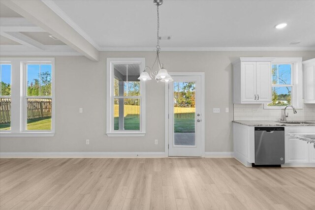 unfurnished dining area featuring crown molding, a notable chandelier, light wood-style floors, a sink, and baseboards