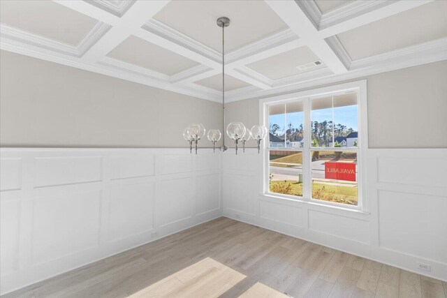 unfurnished dining area with light wood-type flooring, coffered ceiling, visible vents, and a decorative wall