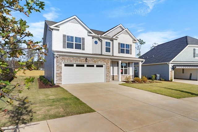 craftsman-style home featuring an attached garage, board and batten siding, stone siding, driveway, and a front lawn