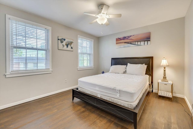 bedroom with ceiling fan and dark hardwood / wood-style flooring