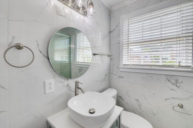 bathroom with vanity, toilet, crown molding, and tile walls