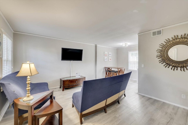 living room featuring light wood-type flooring and crown molding