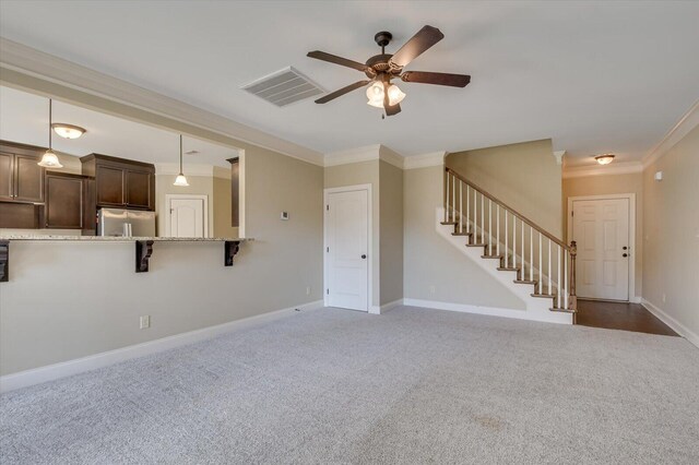 unfurnished living room featuring dark carpet, ceiling fan, and ornamental molding