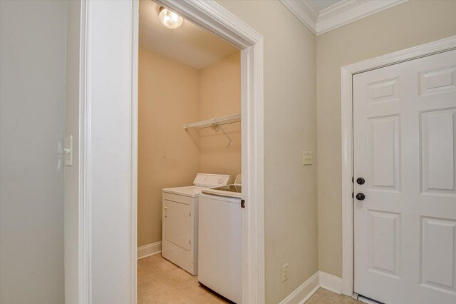 washroom with washing machine and clothes dryer and crown molding