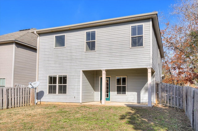 rear view of property with a yard and a patio area