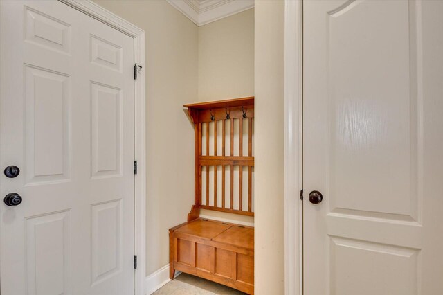 mudroom featuring light tile patterned floors and ornamental molding