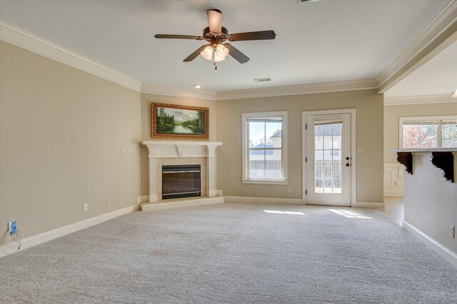 unfurnished living room with a fireplace, light carpet, ceiling fan, and crown molding