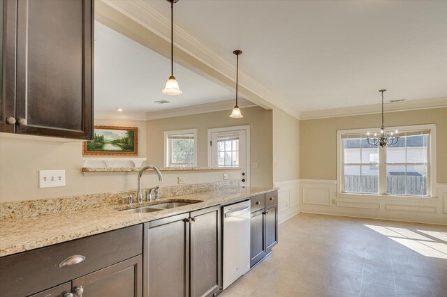 kitchen with light stone countertops, stainless steel dishwasher, dark brown cabinetry, sink, and decorative light fixtures