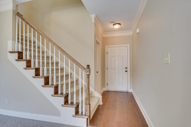 foyer entrance with hardwood / wood-style flooring and ornamental molding