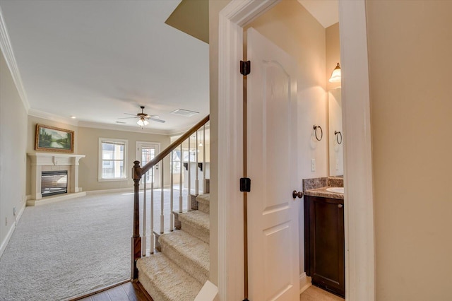 stairway featuring wood-type flooring, ceiling fan, and ornamental molding