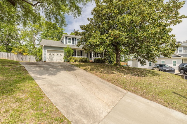view of property hidden behind natural elements with an attached garage, fence, a front lawn, and concrete driveway