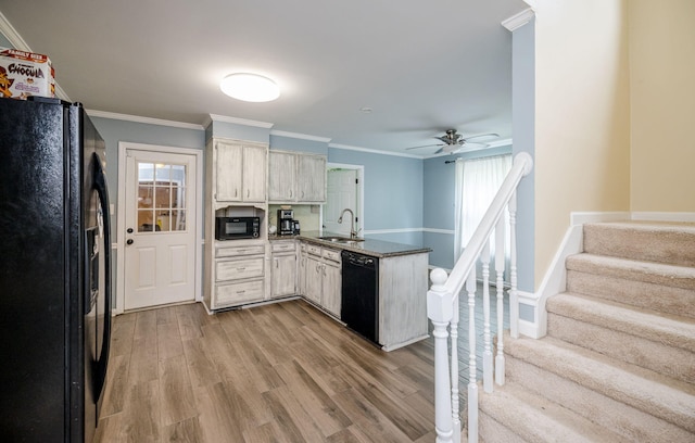 kitchen featuring a peninsula, light wood-style flooring, a ceiling fan, black appliances, and a sink