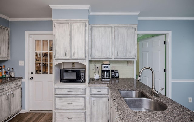 kitchen with dark wood-type flooring, a sink, ornamental molding, and black microwave