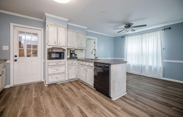 kitchen with a peninsula, black appliances, ceiling fan, a sink, and wood finished floors