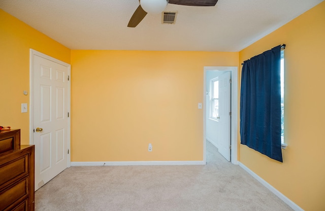 unfurnished bedroom featuring ceiling fan, carpet flooring, baseboards, and visible vents