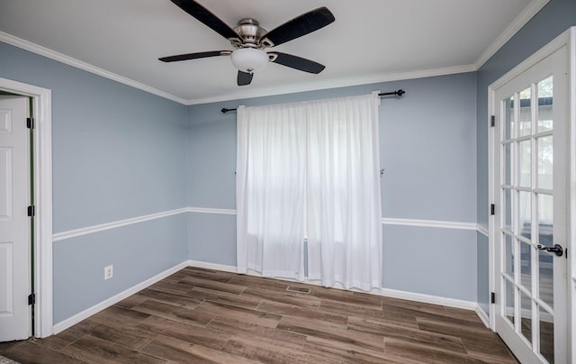 spare room with ceiling fan, baseboards, crown molding, and wood finished floors