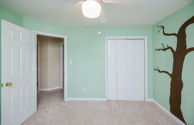 unfurnished bedroom featuring ceiling fan, a closet, carpet flooring, and baseboards