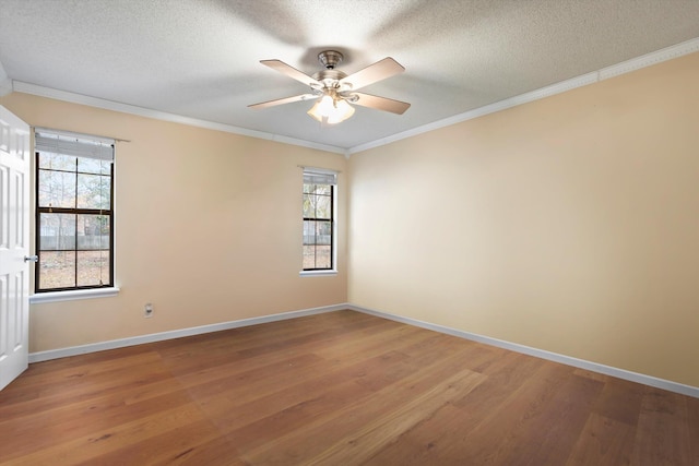 spare room featuring crown molding, plenty of natural light, and hardwood / wood-style flooring