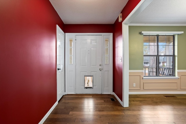 entryway with a textured ceiling and dark wood-type flooring