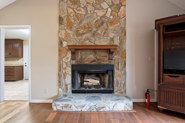 interior details featuring a stone fireplace and hardwood / wood-style floors