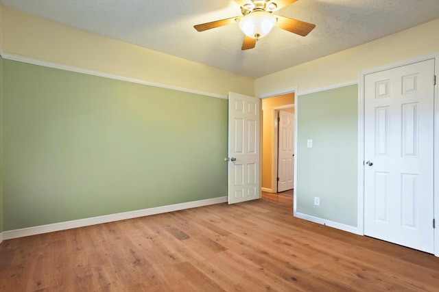 unfurnished bedroom with ceiling fan and wood-type flooring