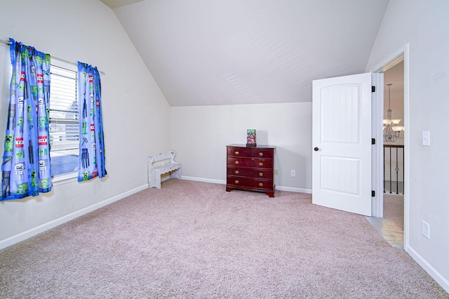 interior space featuring a chandelier, vaulted ceiling, and light colored carpet