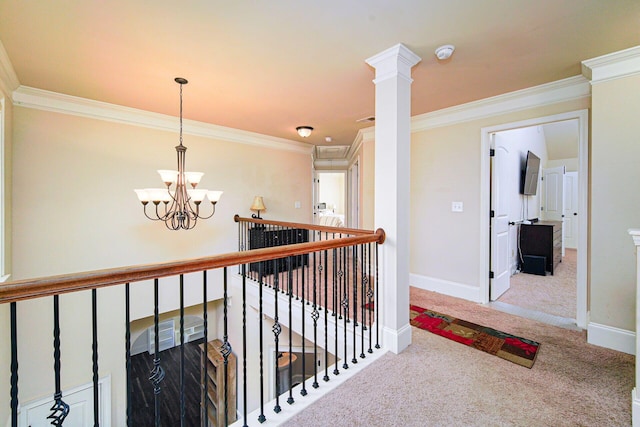 hall with crown molding, a chandelier, and carpet