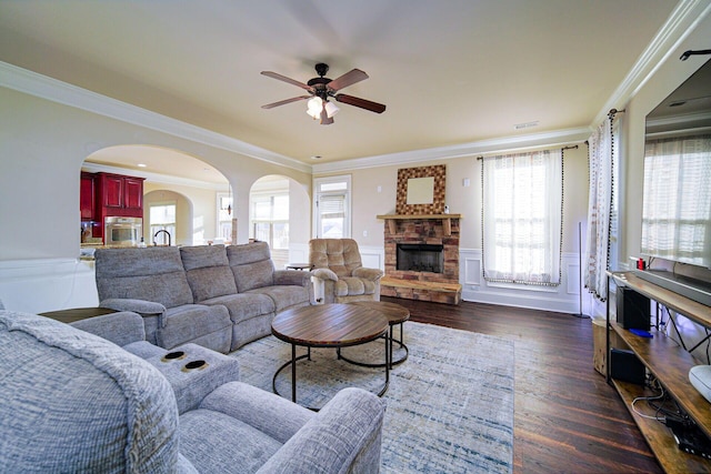 living room with ornamental molding, dark wood-type flooring, and a wealth of natural light