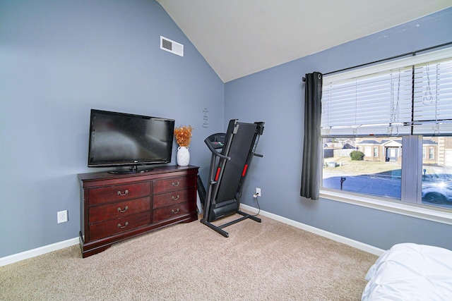 exercise area with lofted ceiling and light colored carpet