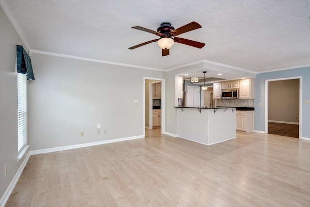 4610 Mulberry Creek Dr, Evans, GA 30809 - unfurnished living room with light wood-type flooring, ceiling fan, crown molding, and a textured ceiling