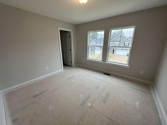 unfurnished room featuring visible vents and baseboards