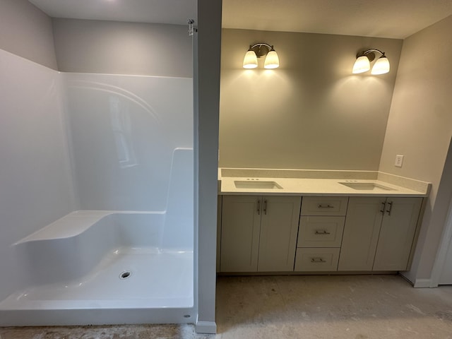 full bath featuring a sink, concrete floors, walk in shower, and double vanity