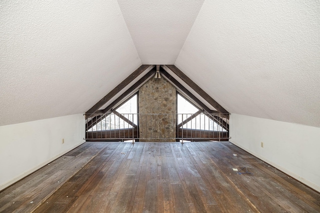 additional living space featuring dark wood-style floors, a textured ceiling, and lofted ceiling