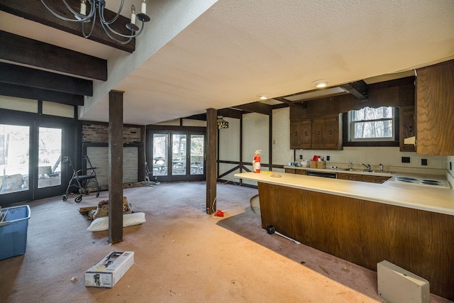 kitchen with light countertops, french doors, a sink, and a healthy amount of sunlight